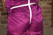 Katharina tied and gagged in a shiny nylon rainsuit