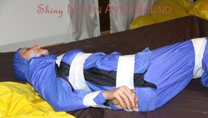 Lucy tied, gagged and hooded with tape by Sophie on bed wearing sexy lightblue rainwear (Pics)