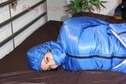 Jill tied, gagged and hooded on bed wearing a supersexy supershiny lightblue downwear (Pics)