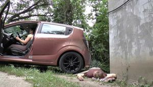 Mistress Jenna stands on the slave with a car while smoking in the slave's mouth A