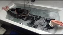 Jill tied and gagged in a bath tub wearing shiny nylon rain pants and a shiny down jacket (Video)