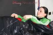 Lucy wearing sexy green shiny nylon shorts and a green rain jacket lolling on bed with a special cover (Pics)