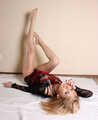 Dolly: blonde barefoot girl, dressed in black top and black panties, poses without restraints, then with rope carada on her body, and then with her hands tied up behind her back and with her feet bound