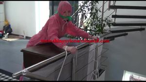 Mara tied and gagged bending over an commode wearing shiny pink nylon rainwear (Video)