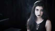 Goth girl with black eyes occasionally prefers dragging a 120mm cigarette
