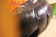Mara wearing a sexy black down pants and an orange down jacket while lolling and reading on the sofa (Pics)