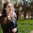 Non smoker Masha is smoking two all white 120mm cigarettes outside
