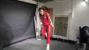 Marie in a custom video suspended in a shiny nylon Jumpsuit