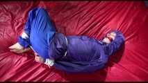 Sonja tied and gagged with ropes and a ballgag on a bed covered with a red shiny nylon cloth wearing a blue shiny nylon rain pants and a purple rain jacket (Video)