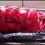 Mara tied, gagged and hooded on bed wearing s shiny red down jacket and a darkblue rain pants (Video)