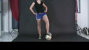 Archive girl posing with a soccer ball wearing a sexy blue shiny nylon shorts and a top (Video)