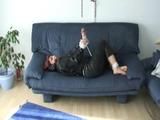 Jill tied and gagged on a blue sofa wearing sexy shiny nylon rainwear (Video)