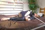 Mara tied and gagged on bed with cuffs wearing a sexy black rainwear jumpsuit (Pics)