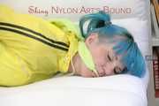 Mara tied and gagged with ropes and cloth gag on a sofa wearing a sexy blue shiny nylon shorts and a yellow/black oldschool rain jacket (Pics)