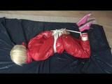 A video with Nina tied and gagged in a shiny PVC suit