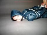 One of our archive girls tied and gagged in shiny nylon rainwear
