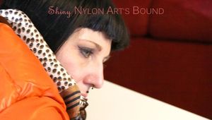 Mara tied and gagged on a table wearing a sexy black down pants and an orange down jacket (Pics)