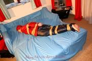 one of our archive girls tied and gagged in shiny nylon rainwear