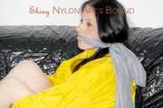 LUCY tied and gagged with ropes and a ballgag on a sofa wearing a sexy black/yellow shiny nylon shorts and a yellow rain jacket (Pics)