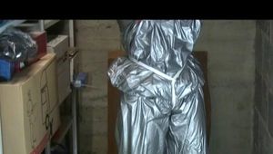 a video with Nicole tied and gagged in a shiny silver PVC sauna suit