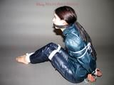 One of our archive girls tied and gagged in shiny nylon rainwear