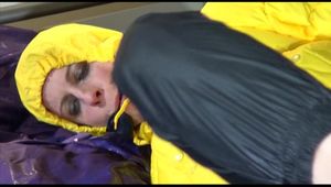 Pia tied, gagged and hooded on bed with cuffs and a gag wearing a hot darkblue rain pants and a big yellow down jacket (Video)
