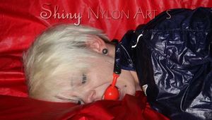 Sexy Courtney being tied and gagged with ropes and a ballgag on a bed wearing dark blue rainwear (Pics)