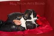 Lucy wearing a black shiny nylon rainh pants and a black down jacket tied and gagged on a sofa (Pics)