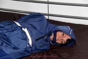 Simone tied and gagged in a shiny nylon rainsuit and a shiny nylon cape