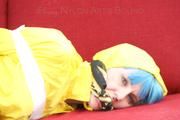 Mara tied, gagged and hooded with tape on a red sofa wearing shiny yellow rainwear (Pics)