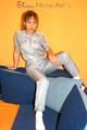 Leonie posing on a sofa wearing a grey adidas shiny nylon rainwear (Pics)