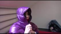 Jill ties and gagges herself sitting on a bed wearing a sexy shiny nylon rain pants and a purple down jacket (Video)