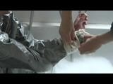 Simone  with an shiny silver PVC sauna suit tied and gagged by Sophie in an bath tub (Video)