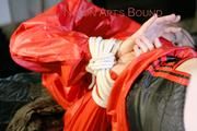 Sonja tied and gagged in bed wearing black hot shiny nylon shorts and a red rain jacket (Pics)