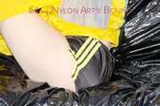 LUCY tied and gagged with ropes and a ballgag on a sofa wearing a sexy black/yellow shiny nylon shorts and a yellow rain jacket (Pics)