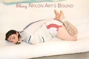 JIll tied and gagged on a white sofa wearing a sexy white/red shiny nylon shorts and a white rain jacket (Pics)
