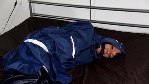 Simone tied and gagged in a shiny nylon rainsuit and a shiny nylon cape