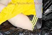 LUCY tied and gagged with ropes and a ballgag on a sofa wearing a sexy black/yellow shiny nylon shorts and a yellow rain jacket (Pics)