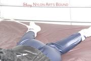 Shelly tied and gagged on a bed with downjacket and shiny rainsuit