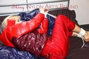 Pia tied and gagged on bed wearing a shiny red rain pants and a shiny red/purple down jacket (Pics)