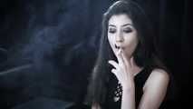 Goth girl with black eyes occasionally prefers dragging a 120mm cigarette