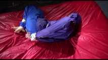 Sonja tied and gagged with ropes and a ballgag on a bed covered with a red shiny nylon cloth wearing a blue shiny nylon rain pants and a purple rain jacket (Video)