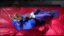 Sonja tied and gagged with ropes and a ballgag on a bed covered with a red shiny nylon cloth wearing a blue shiny nylon rain pants and a purple rain jacket (Video)