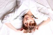 Topless barefoot Polina in unbuttoned white shirt and black jeans, bound with red ropes, poses on the floor