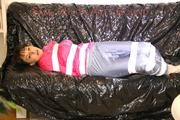 Mara tied, gagged and hooded with tape on a sexy black covered sofa wearing a supersexy grey rain pants and a pink rain jacket (Pics)