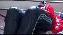 Mara tied, gagged and hooded on bed wearing s shiny red down jacket and a darkblue rain pants (Video)