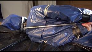 Pia tied, gagged and hooded in bed wearing a sexy blue AGU rainwear combination (Video9