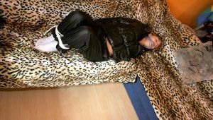 one of our archive girls bound and gagged in a shiny nylon down jacket