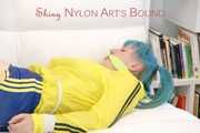 Mara tied and gagged with ropes and cloth gag on a sofa wearing a sexy blue shiny nylon shorts and a yellow/black oldschool rain jacket (Pics)