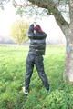 Jill tied and gagged outdoor on a tree wearing a sexy black downjacket and a black rain pants (Pics)